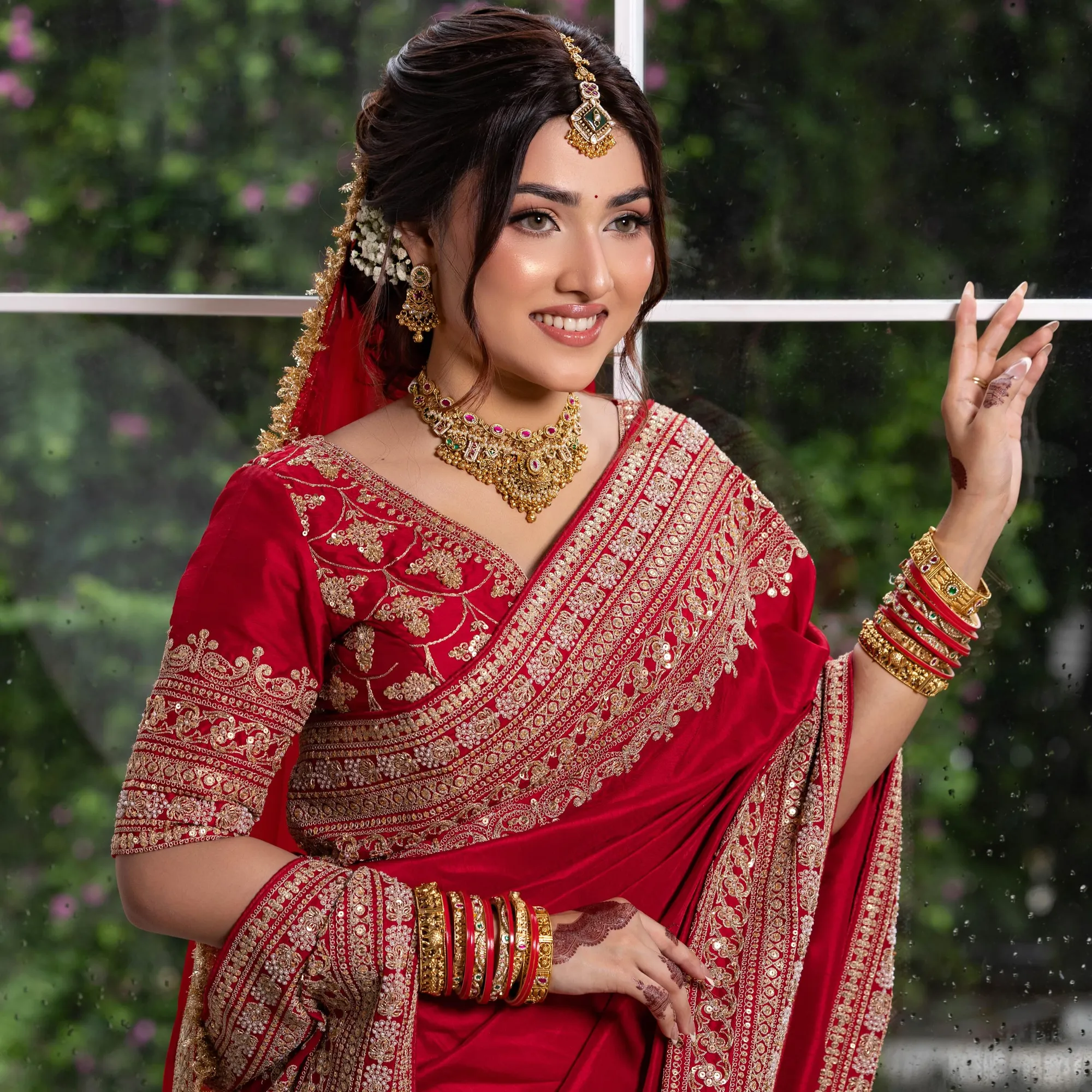 Bride in a red saree with gold embroidery, choker and bangles, a karwa chauth look in saree